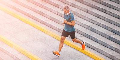 Healthy 40-something man runs down stairs and would probably qualify for a healthy life insurance rating.