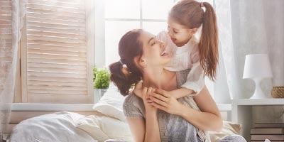 Young mother and daughter at home thinking while mother thinks about whether she should buy life insurance for her child. 