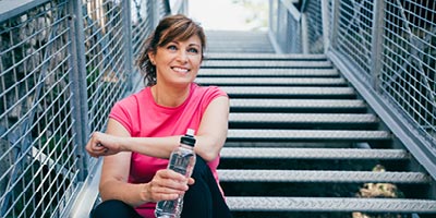 Woman on stairs after workout wondering what life insurance rating or classification she might qualify for