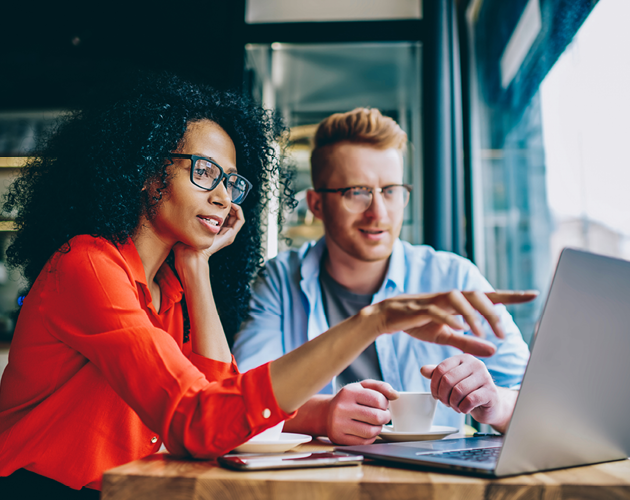 Woman and man looking at laptop screen.