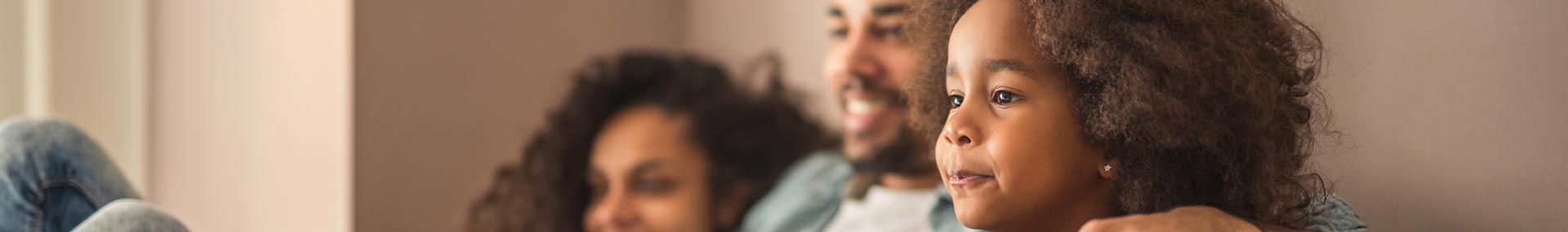 Father, mother and daughter sitting together at home.