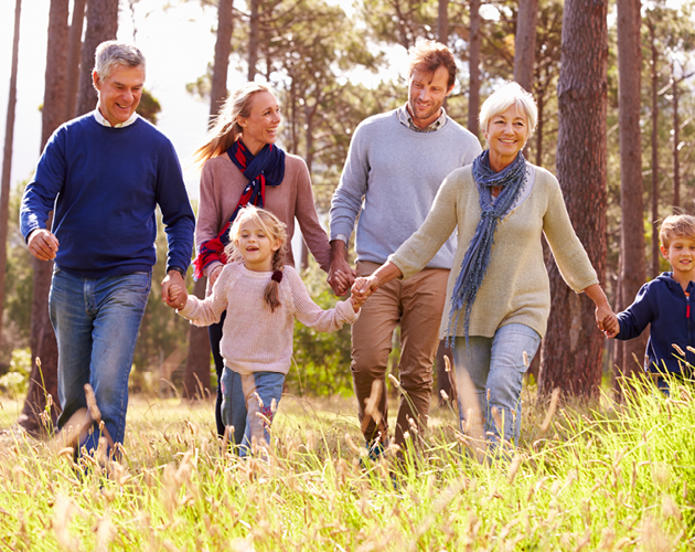 Multi-generational family walking in a field.