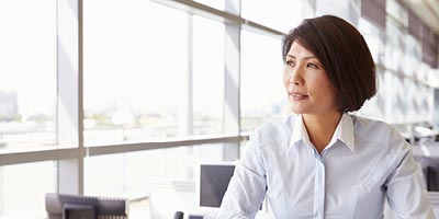 Woman in an office setting staring out the window. 