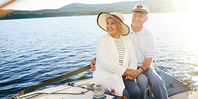 A senior adult couple sailing on the ocean. 