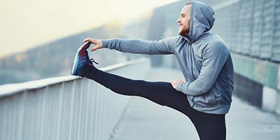 Man stretching his leg after a run outside.