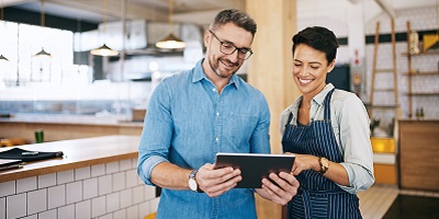 Man and his client looking at an tablet together, as if reviewing insurance options