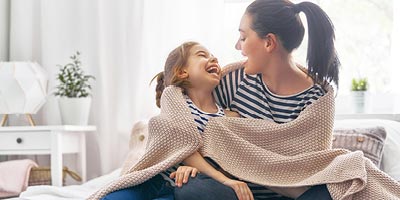 Mother and daughter laughing; mother is worried if she can get life insurance on her ex