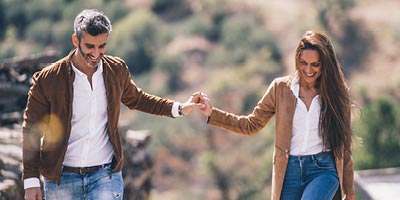 Couple walking along a trail holding hands.
