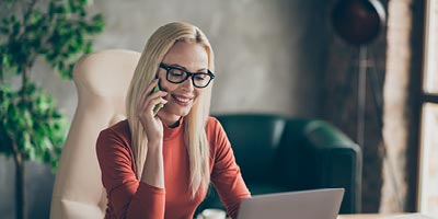 Young woman speaking with a life insurance agent over the phone to discuss her life insurance coverage options.