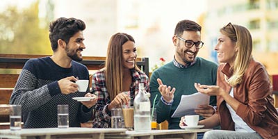 A group of young adults smiling while discussing information about life insurance.