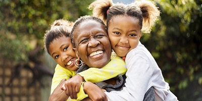 Two young African American girls hugging their grandma
