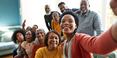 Multi-generational family laughing and making a picture together.