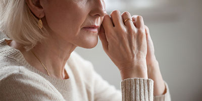  Woman reflecting as she debates using her life insurance policy for terminal illness. 