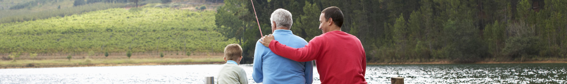 Adult son fishing with elder father and young son symbolizing families that are caring for aging parents and young children.