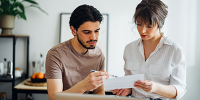 Middle aged couple at home looking at a document together.