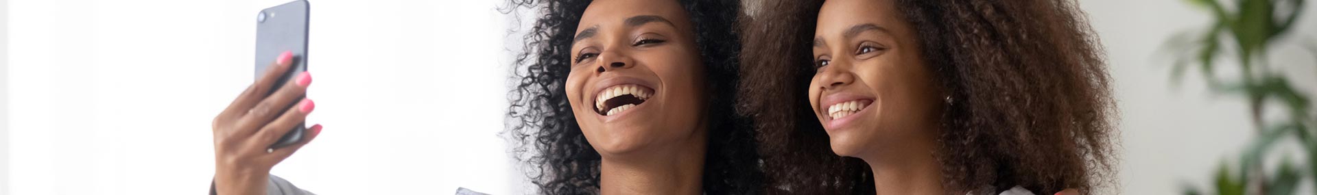 African-American mother and young teenage daughter taking a selfie and family is planning for her college.