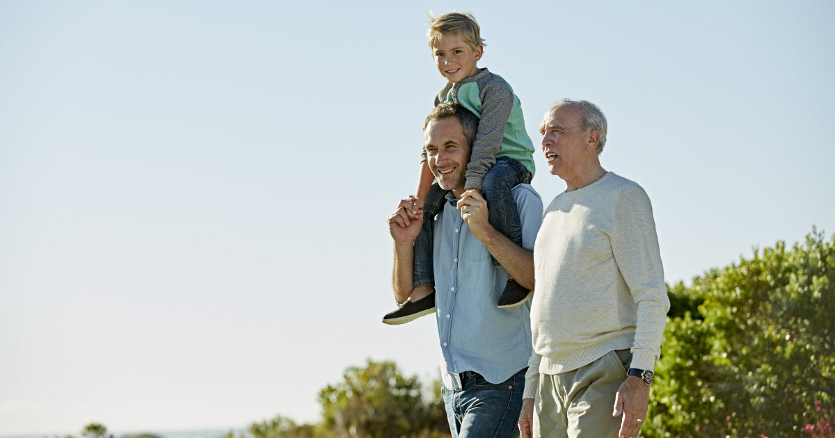 Grandfather, father and son walking outside near ocean