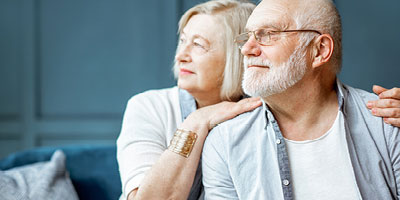 Senior aged couple staring off into the distance.