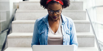 Young woman browsing the internet on a laptop.