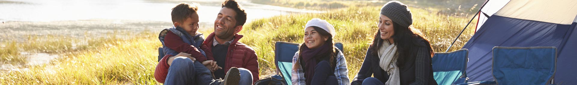 Parents camping with their two children symbolizing that they have a lot of financial planning to prepare for in the future