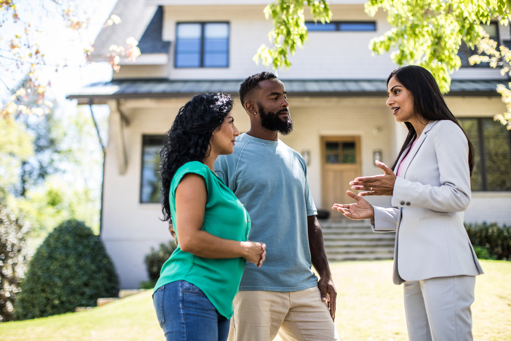 A couple discussing a real estate property with an agent prior to purchasing the property.