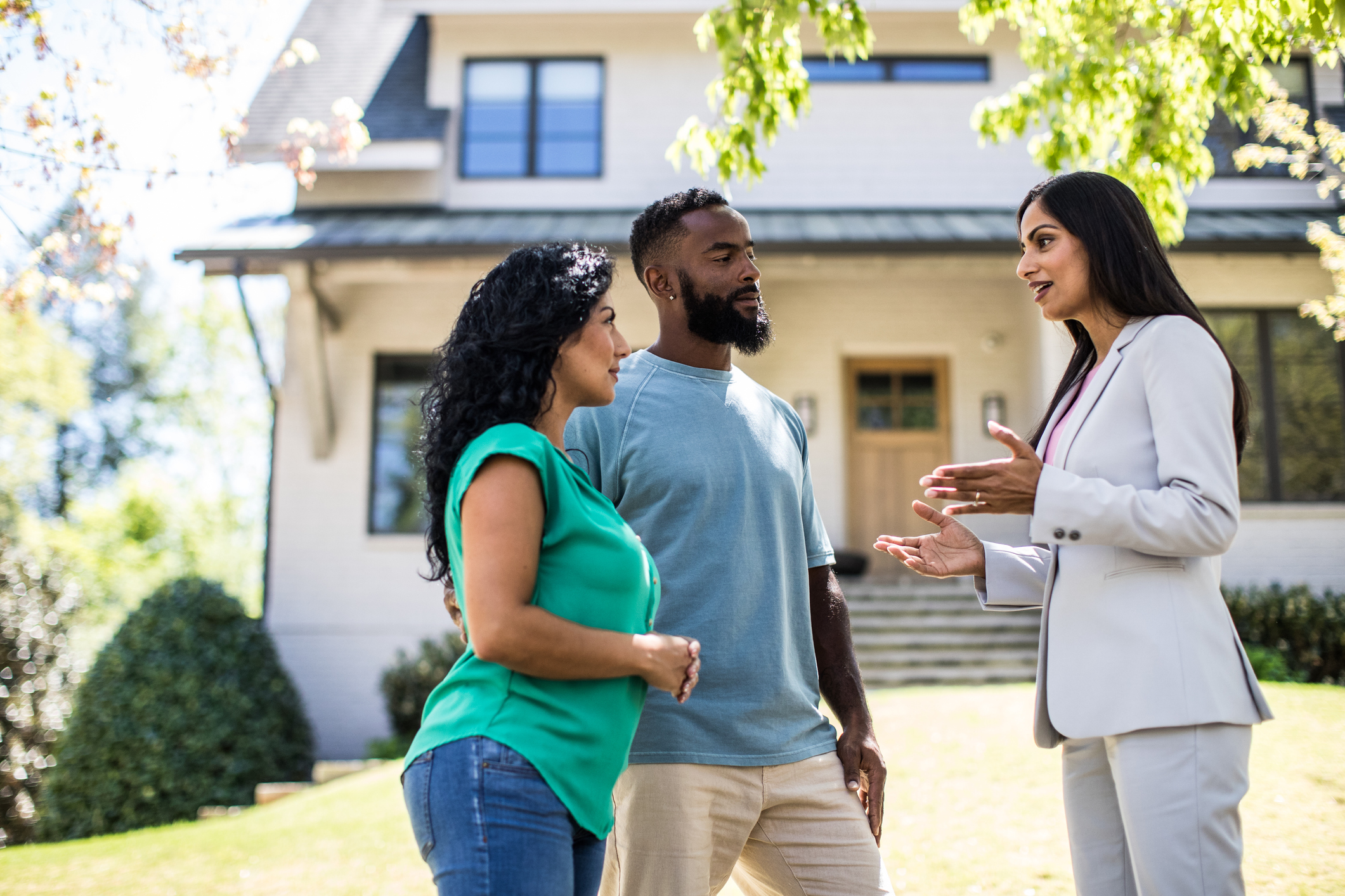 A couple discussing a real estate property with an agent prior to purchasing the property. 