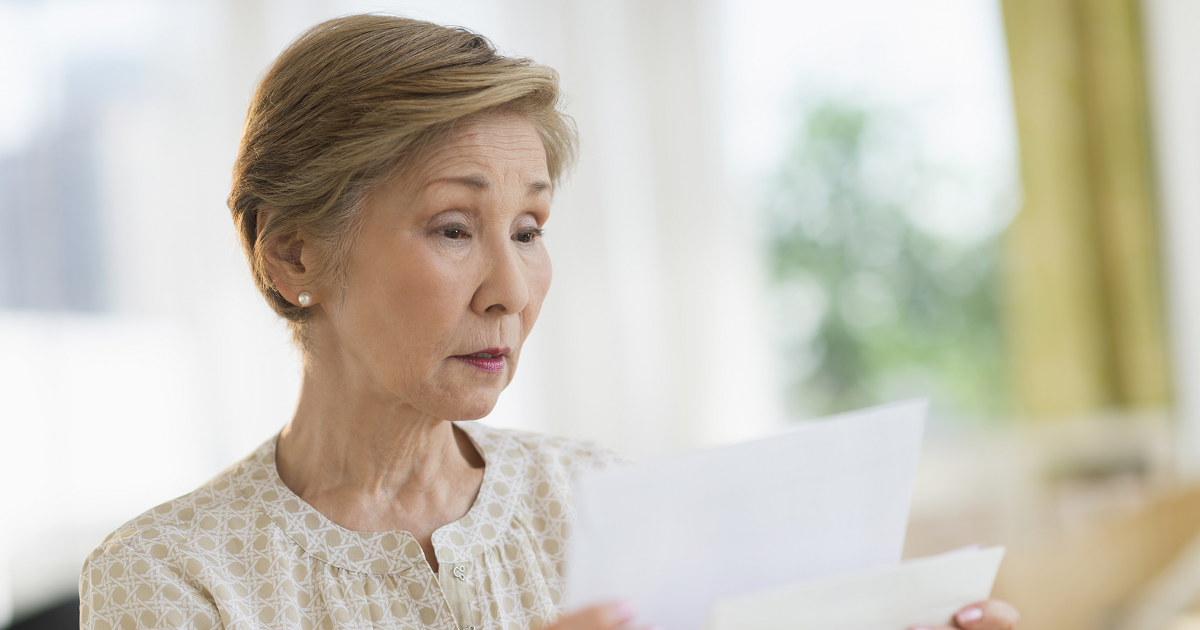 Senior woman sorting through mail.