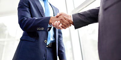 Two men shaking hands to indicate developing a financial plan