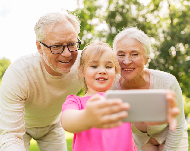 Grandparents taking a selfie with young granddaughter.