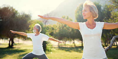 Senior couple doing stretches outside on a beuatiful day.