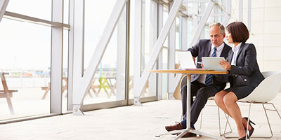 A man and woman discussing business at a table