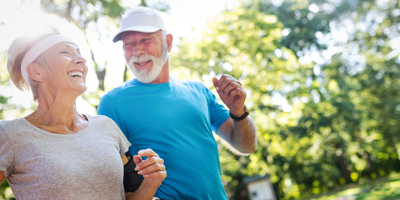 Senior couple going for a jog and laughing and talking together.