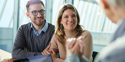 A young couple looking happy about their financial future