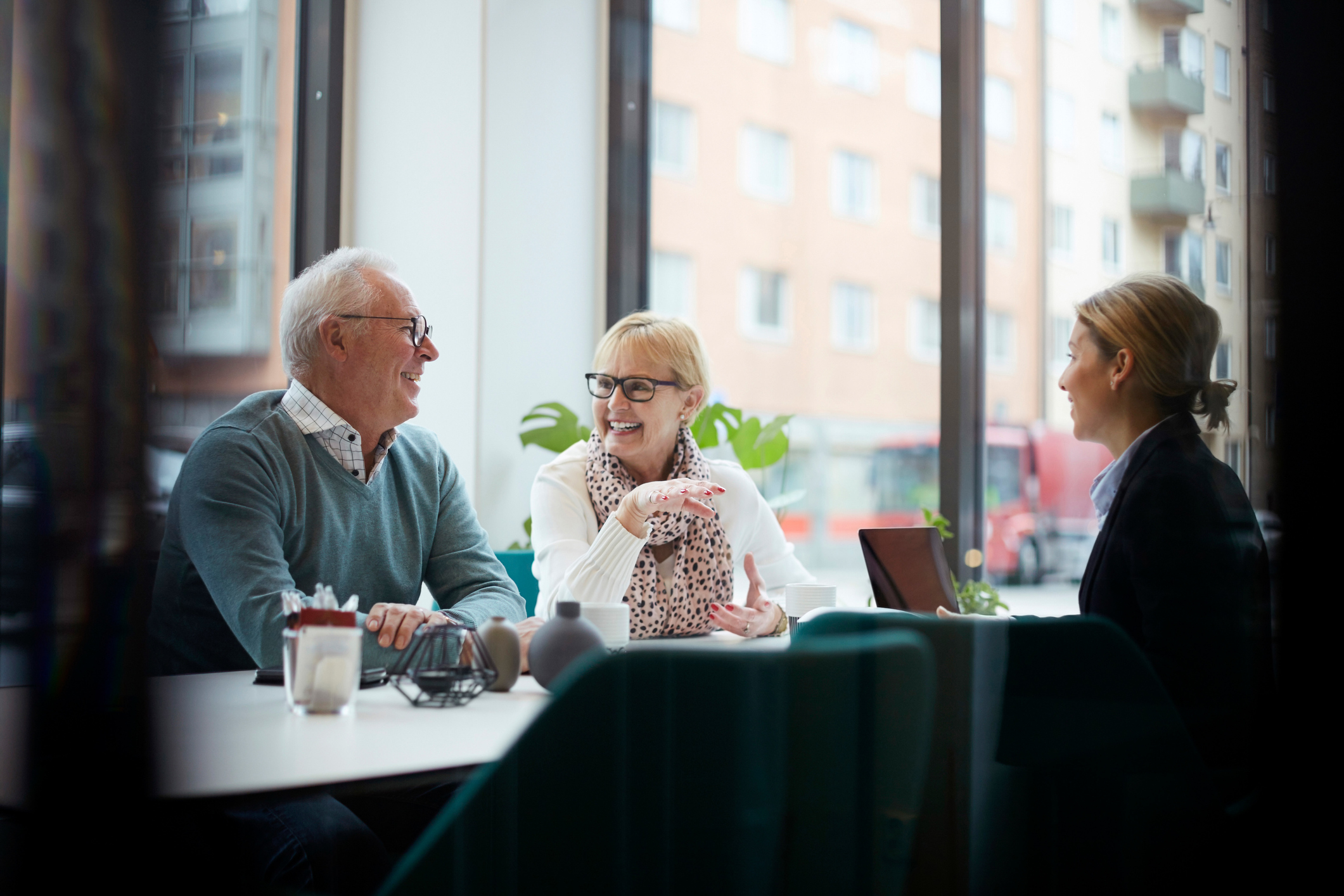 A senior couple enjoys lunch with their daughter.