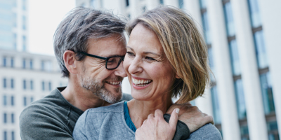 Middle-aged couple shares a loving embrace while out in the city.