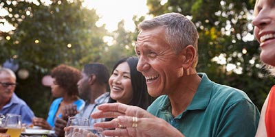 Fifty-something man at outdoor party laughing