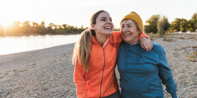 Mother and daughter enjoying afternoon walk together by the lake.