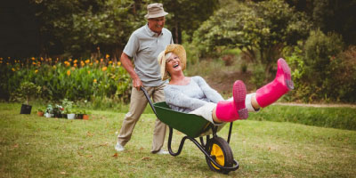 A senior couple playfully outdoors doing yard work.