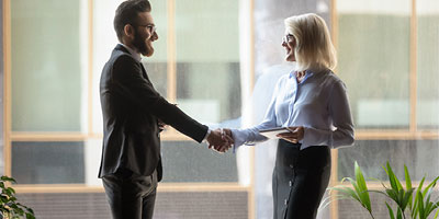 A mature woman meeting with her financial advisor to discuss the tax benefits of converting her traditional IRA to a roth IRA.
