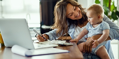 Mom looking at baby while writing on paper