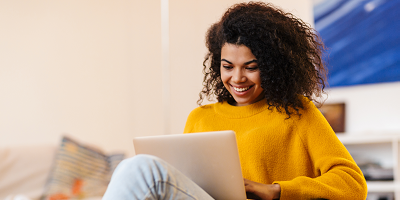 Young woman smiling as she works on her computer