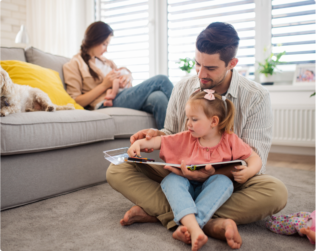 A man and a woman care for their two young children in their home.