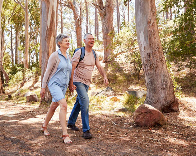 Senior couple walks through the woods together on a hike