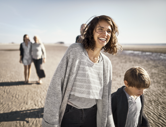 Mother and young son walking on beach