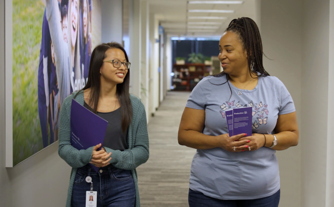 Two Protective teammates in conversation as they walk down the hallway