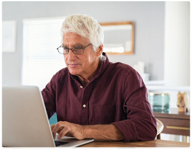 A man using a laptop to access his Protective Immediate Benefit Account online.
