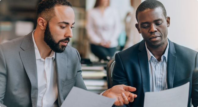 2 men in business casual attire review Protective's Code of Conduct.