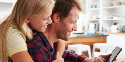 Preteen daughter hugging her seated father from behind