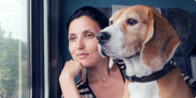 Woman gazes through a window with her dog