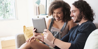 Man and woman smiling at ipad